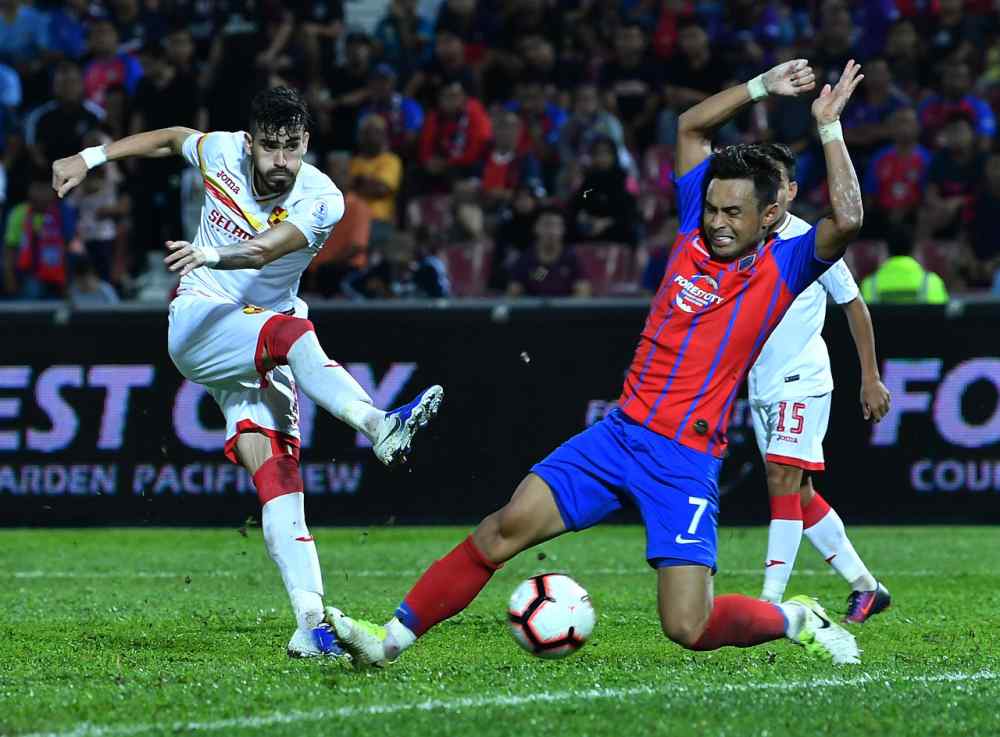 JDTu00e2u20acu2122s Mohamad Aidil Zafuan Abd Radzak tries to block Selangor player Endrick Dos Santos Parafitau00e2u20acu2122s shot during the match in Larkin June 20, 2019. u00e2u20acu2022 Bernama pic