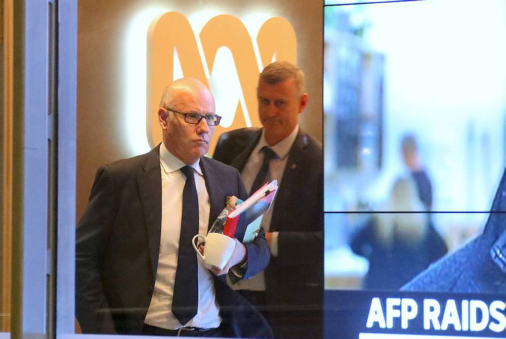 John Lyons (left), Executive Editor of ABC News, is followed by an Australian Federal Police officer out the main entrance to the ABC building in Sydney June 5, 2019. u00e2u20acu201d AAP Image/David Gray via Reuters