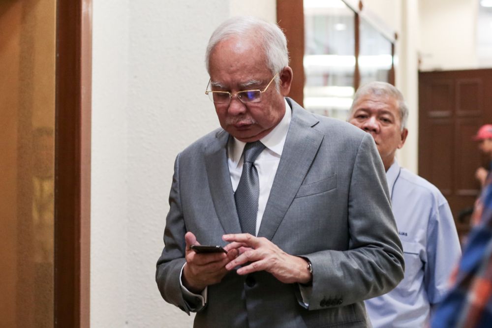 Datuk Seri Najib Razak checks his phone at the Kuala Lumpur Court Complex June 11, 2019. u00e2u20acu201d Picture by Ahmad Zamzahuri