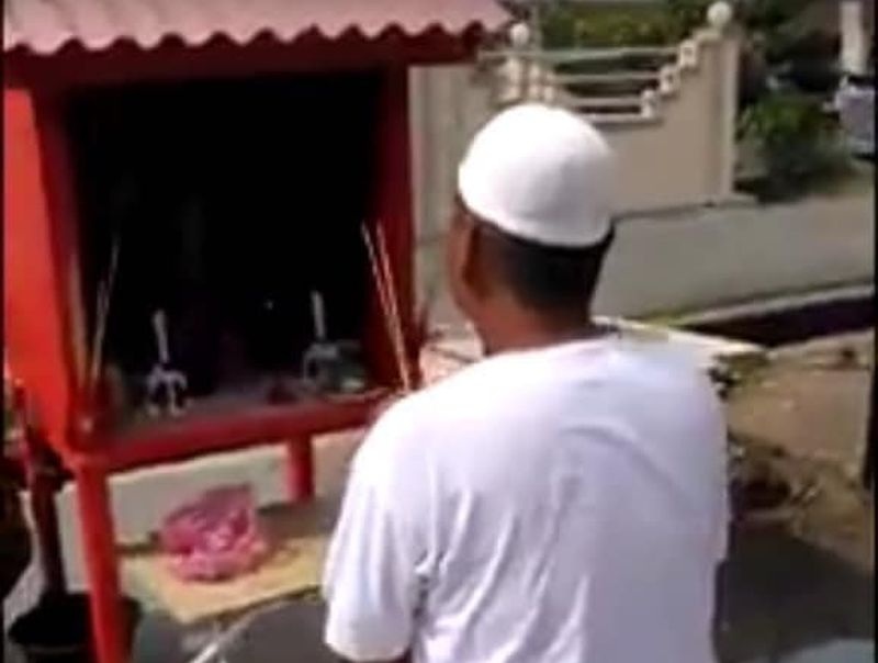Paparan skrin menunjukkan seorang lelaki berkopiah dan berkain pelikat membuat sembahan di tokong dalam rakaman yang tular di media sosial. 