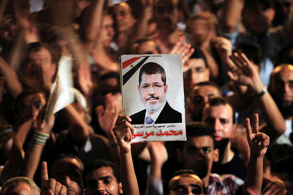 A picture of Egypt's first Islamist President Mohamed Mursi is held up as supporters cheer during a rally at Tahrir Square in Cairo July 13, 2012. u00e2u20acu201d Reuters pic