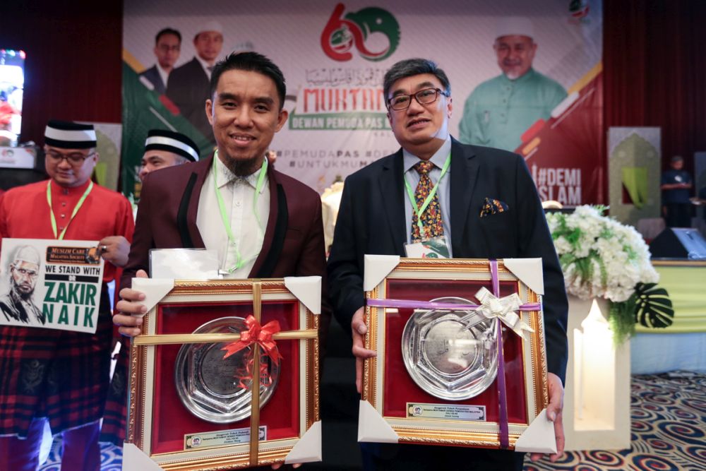 Jason Leong (right) and Firdaus Wong pose with their awards during PAS Youthu00e2u20acu2122s 60th muktamar in Bukit Gambang Resort City, Pahang June 19, 2019. u00e2u20acu201d Picture by Ahmad Zamzahuri