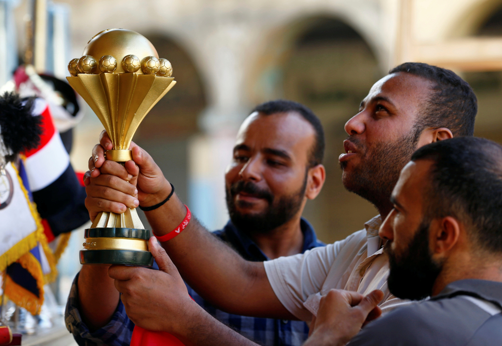 Customers hold a model of the Africa Cup of Nationsu00e2u20acu2122 trophy at a shop at Al Ataba, Cairo June 16, 2019. u00e2u20acu201d Reuters pic