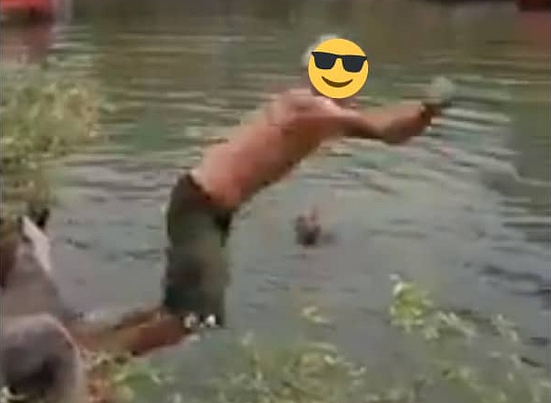 Screengrab from a viral video featuring a group of men taking a dip in Sungai Melaka waterway. u00e2u20acu201d Picture via Twitter/anthraxxxx