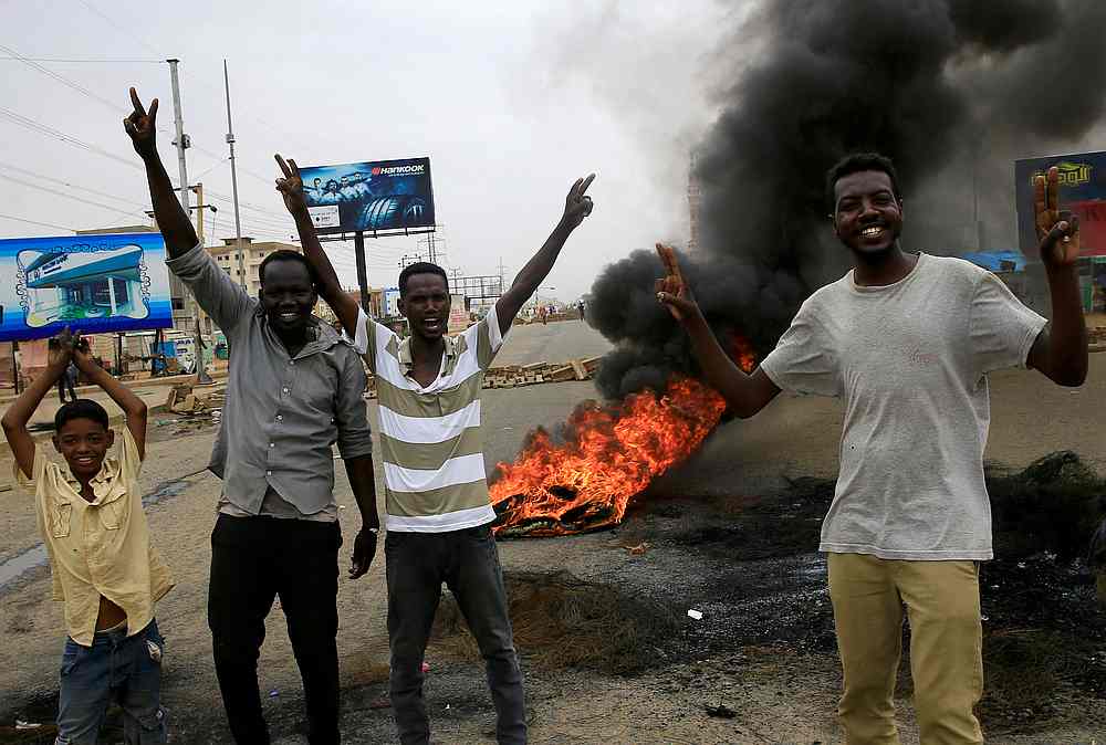 Sudanese protesters gesture near burning tyres used to erect a barricade on a street, demanding that the country's Transitional Military Council handover power to civilians, in Khartoum June 4, 2019. u00e2u20acu201d Reuters pic