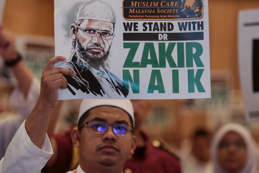 A PAS member holds up a placard to show his support for Dr Zakir Naik during Muktamar 2019 in Gambang, Pahang June 19, 2019. u00e2u20acu201d Picture by Ahmad Zamzahuri