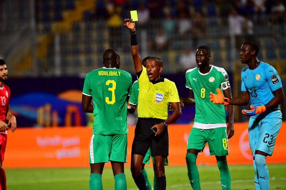 Ethiopian referee Bamlak Tessema Weyesa shows a yellow card to Senegalu00e2u20acu2122s defender Kalidou Koulibaly during the 2019 Africa Cup of Nations (CAN) semi-final match with Tunisia at the 30 June stadium in Cairo July 14, 2019. u00e2u20acu201d AFP pic