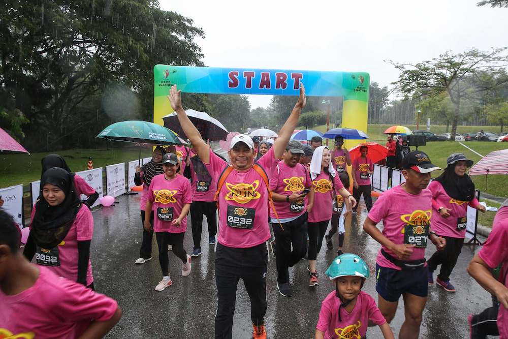 Contestants of the Venus Fun Run not letting a little rain get in their way as they race to complete the five-kilometre run. — Picture by Yusof Mat Isa. 