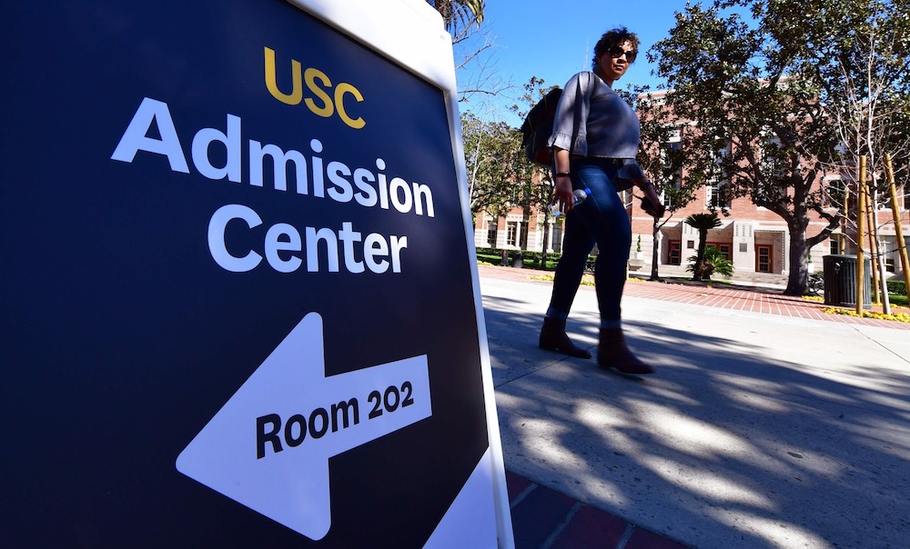 A woman walks past a sign directing people toward USC's Admission Centre at the University of Southern California (USC) in Los Angeles March 13, 2019. u00e2u20acu201d AFP pic 