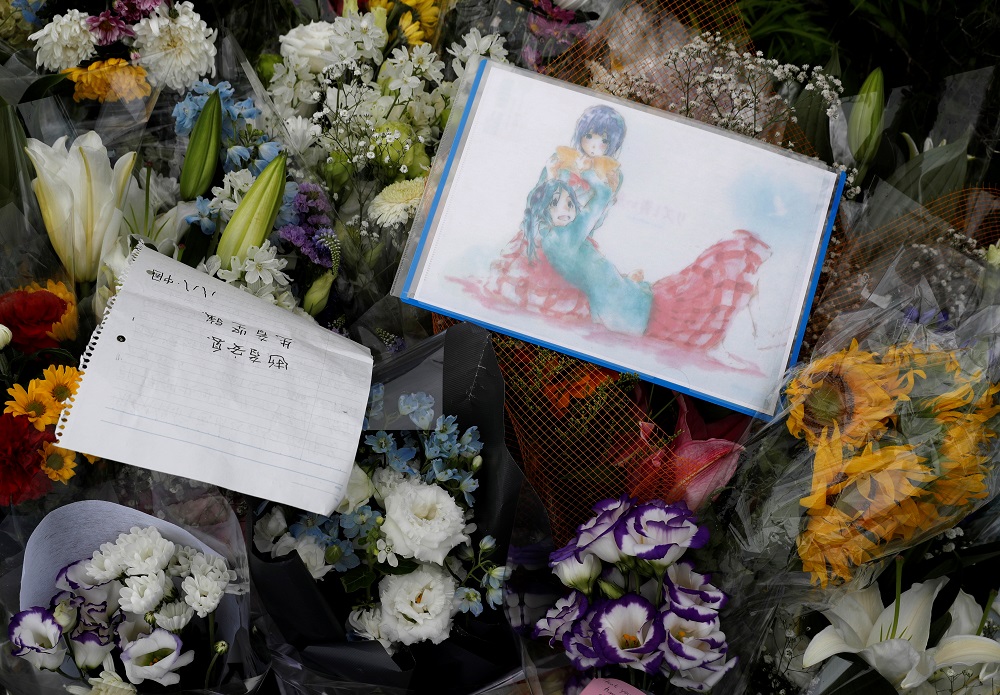 Flowers and a drawing with anime characters dedicated to the victims of the fire are seen left outside the Kyoto Animation building which was torched by arson attack, in Kyoto July 19, 2019. u00e2u20acu201d Reuters pic