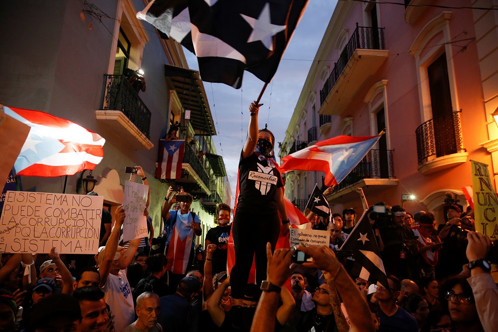 A hooded demonstrator waves a Puerto Rican flag during the seventh day of protest calling for the resignation of Governor Ricardo Rossello in San Juan July 19, 2019. u00e2u20acu201d Reuters pic