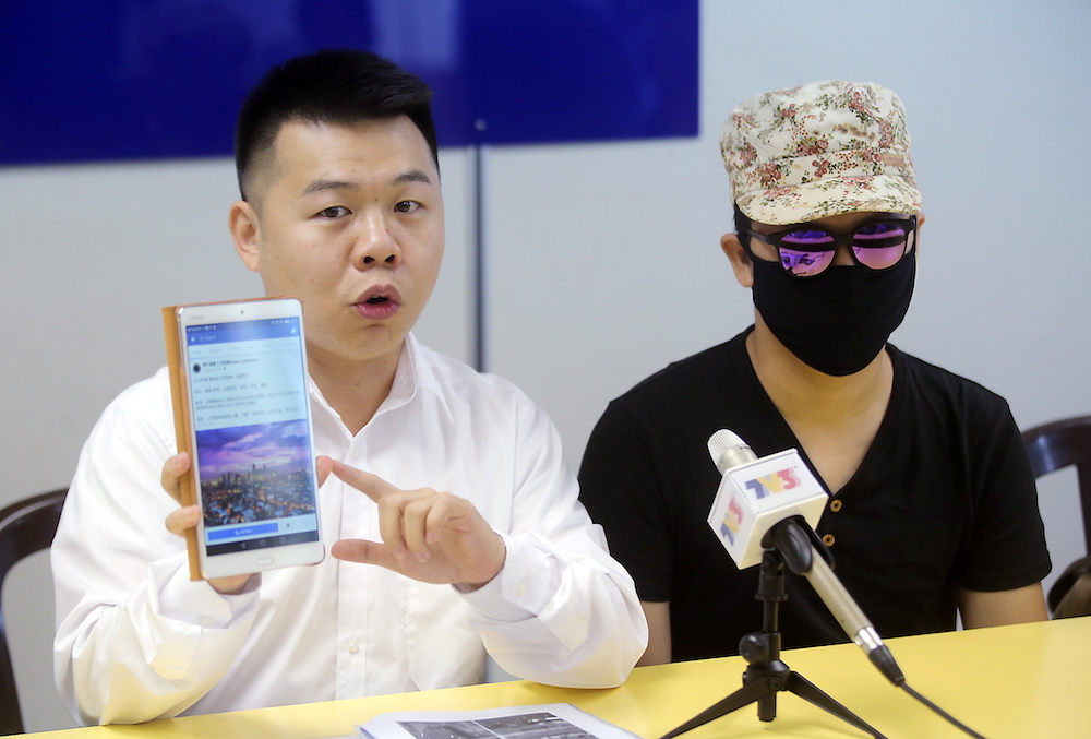 Perak MCA Public Services and Complaints Bureau chief Low Guo Nan and Leong show the details of the incident where the latter was cheated of RM13,000 and forced to work in an illegal online gambling centre in the Philippines. u00e2u20acu201d Picture by Farhan Najib