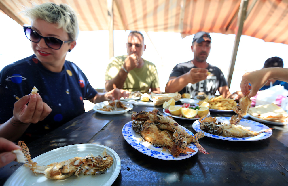 Jina Talj, an environmentalist, eats fried lionfish, a predatory venomous fish native to the nearby Red Sea and the Indo-Pacific, in Sarafand, Lebanon June 20, 2019. u00e2u20acu201d Reuters picnn