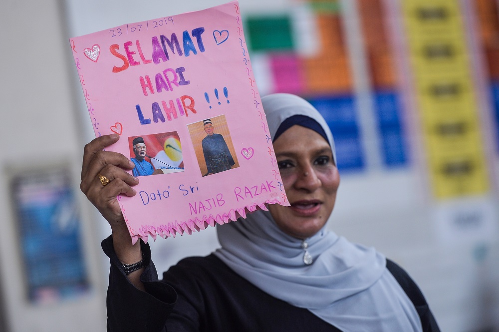 A supporter holds up a birthday card for Datuk Seri Najib Razak at the lobby of the Kuala Lumpur Court Complex July 23, 2019. — Picture by Mukhriz Hazim 
