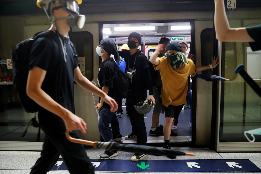 Protesters hold the door of a Mass Transit Railway (MTR) subway to allow more protesters to board and retreat, after a protest against police violence in Hong Kong July 28, 2019. u00e2u20acu201d Reuters  pic