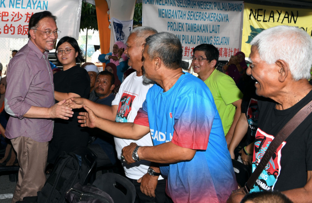 PKR president Datuk Seri Anwar Ibrahim shakes hands with fishermen from Sungai Batu Teluk Kumbar at a meeting with residents and fishermen at Permatang Damar Laut in Penang July 13, 2019. u00e2u20acu201d Bernama pic 