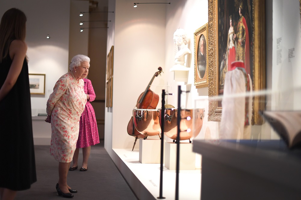 Britain's Queen Elizabeth II looks at musical instruments used by Queen Victoria's private orchestra, as part of an exhibition to mark the 200th anniversary of the birth of Queen Victoria, for the Summer Opening of Buckingham Palace in London July 17, 2019. — AFP pic
