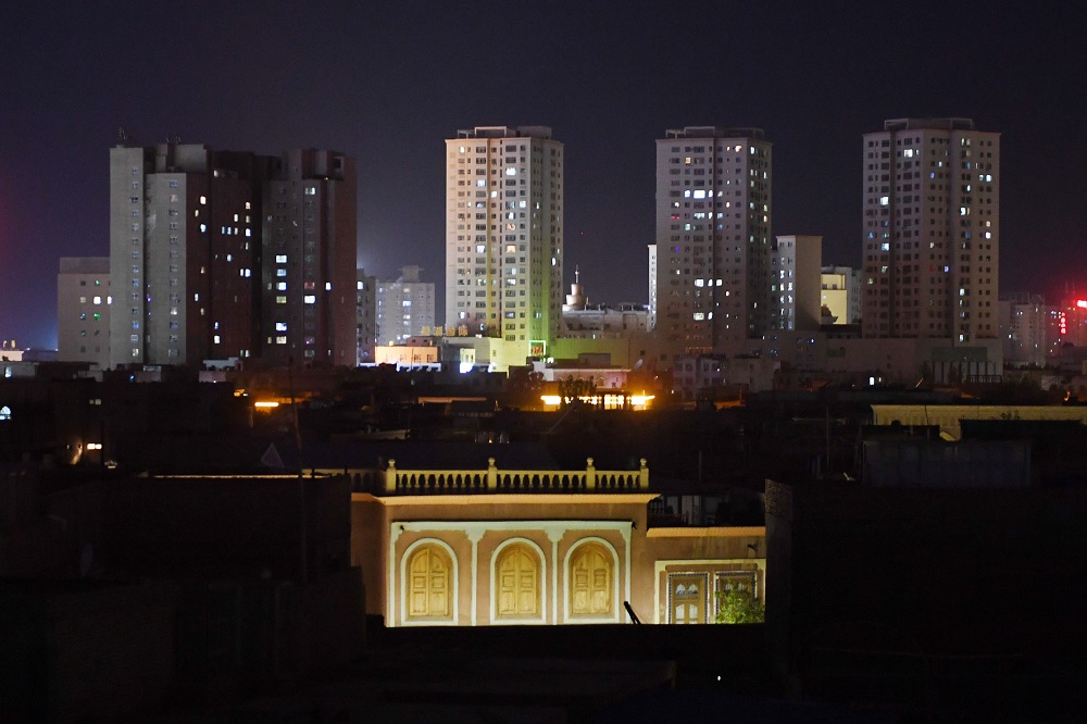 This photo taken on June 2, 2019 shows modern apartment buildings in the distance behind traditional Uighur houses in Kashgar in China’s northwest Xinjiang region. — AFP pic        