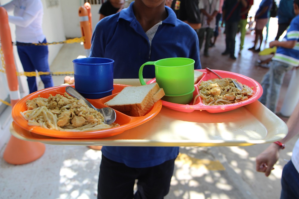 A Venezuelan migrant shows the free meal he receives from Rancheria community kitchen managed by the United Nations World Food Programme in Riohacha town in La Guajira region June 5, 2019. u00e2u20acu201d Thomson Reuters Foundation pic