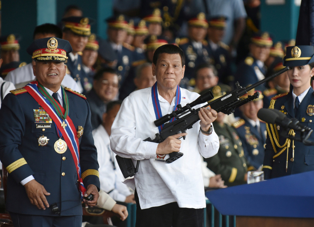 Philippine President Rodrigo Duterte holds a Galil sniper rifle next to outgoing National Police Chief Ronald Bato Dela Rosa during the National Police chief handover ceremony in Camp Crame, Quezon City, Manila, Philippines, April 19, 2018. u00e2u20acu201d Reuters pi