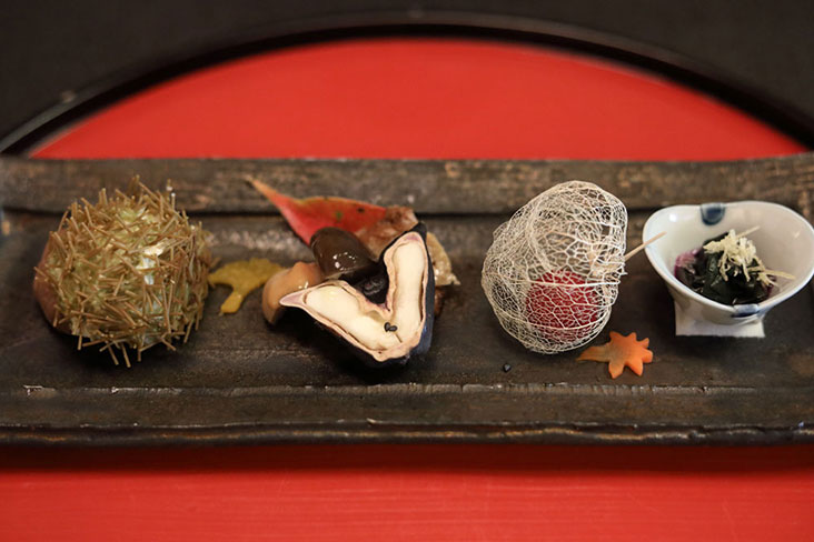 'Hassun' course (left to right): 'kuri' chestnut; miso-marinated mushrooms with water chestnuts and wheat gluten; “mountain peach” ('yamamomo') inside a Japanese lantern ('hozuki'); and stewed spinach with grated candied ginger