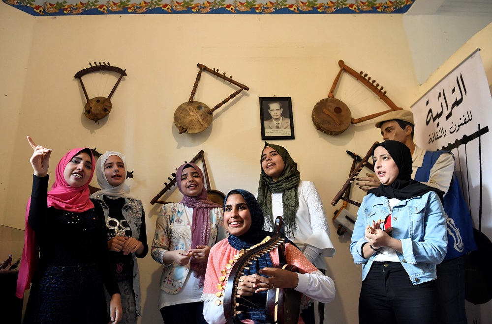 Iman Haddo (centre), a 20-year-old musician, plays a semsemia fan during a music session at the Canal 20 cultural museum in the northeastern city of Port Said at the northern terminus of the Suez Canal May 29, 2019. — AFP pic     