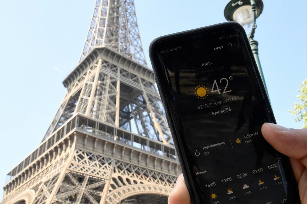 A person standing next to the Eiffel Tower holds a smartphone indicating a temperature of 42 degrees Celsius, on July 25, 2019 in Paris, as a new heatwave hits the French capital. u00e2u20acu201d AFP pic