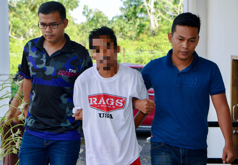 A rubber tapper is brought to the Segamat Court Complex July 13, 2019. He is accused of murdering two senior citizens in Buloh Kasap. u00e2u20acu201d Bernama pic