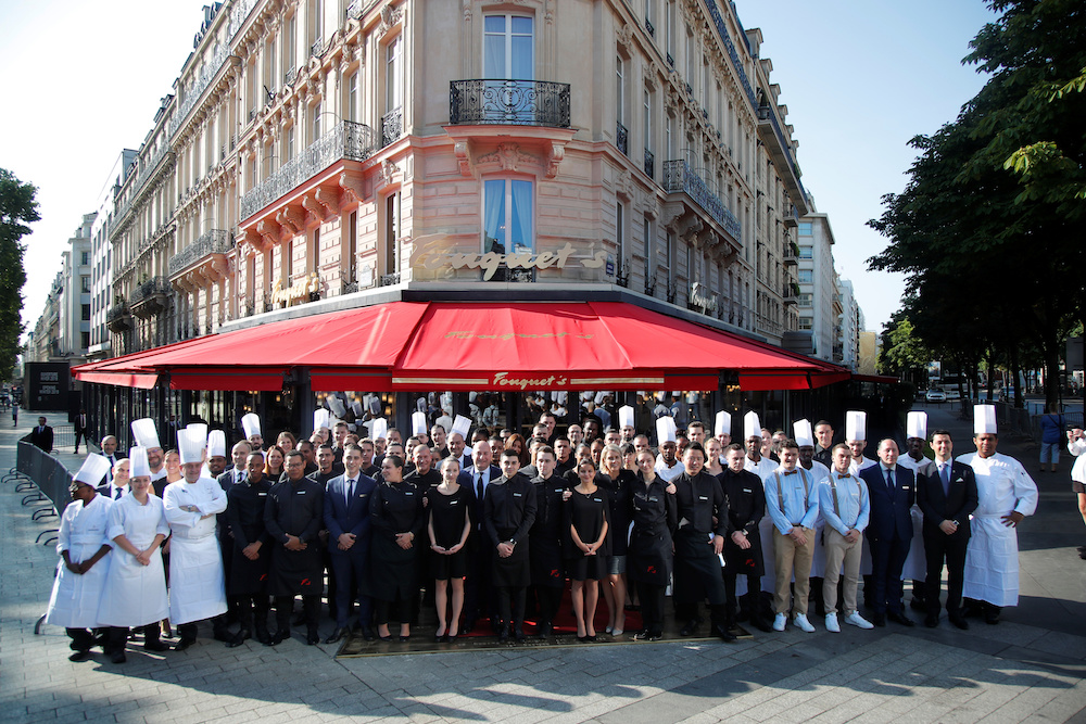 Employees of the Fouquetu00e2u20acu2122s restaurant pose together on the eve of its reopening on the Champs Elysees, almost 4 months after it was ranksacked by a u00e2u20acu02dcyellow vestsu00e2u20acu2122 protest in Paris, France, July 13, 2019. u00e2u20acu201d Reuters pic