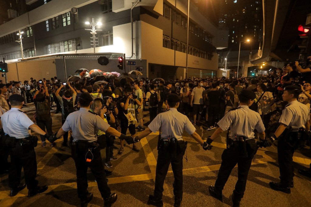 Policemen hold hands to line up and surround protesters during a demonstration in the north-western district of Tuen Mun, near the border with the Chinese city of Shenzhen, in Hong Kong on July 6, 2019. u00e2u20acu201d AFP pic
