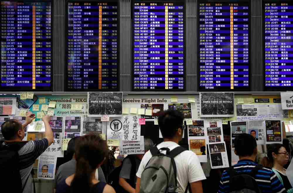 Demonstrators paste post-it notes and banners under an information screen during a protest against the recent violence in Yuen Long, at Hong Kong airport, July 26, 2019. u00e2u20acu2022 Reuters pic