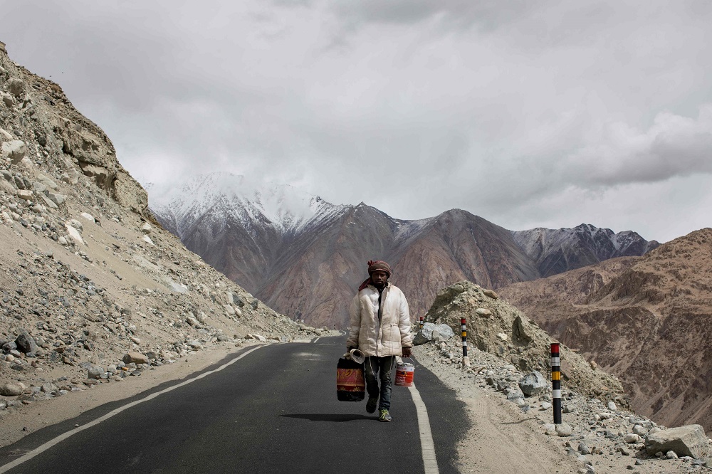 In this picture taken on May 18, 2019, Rajesh Manji, 28, a road maintenance worker carries buckets of paint to restore road markers along Pangong Lake road near the Chang La pass in northern India's Ladakh region of Jammu and Kashmir state. u00e2u20acu2022 AFP pic   