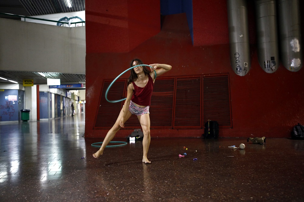 Stav Pinto, 24, uses a hula hoop as she practices her acrobatics skills during a weekly informal circus community meeting at the Central Bus Station in Tel Aviv, Israel July 1, 2019. — Reuters pic