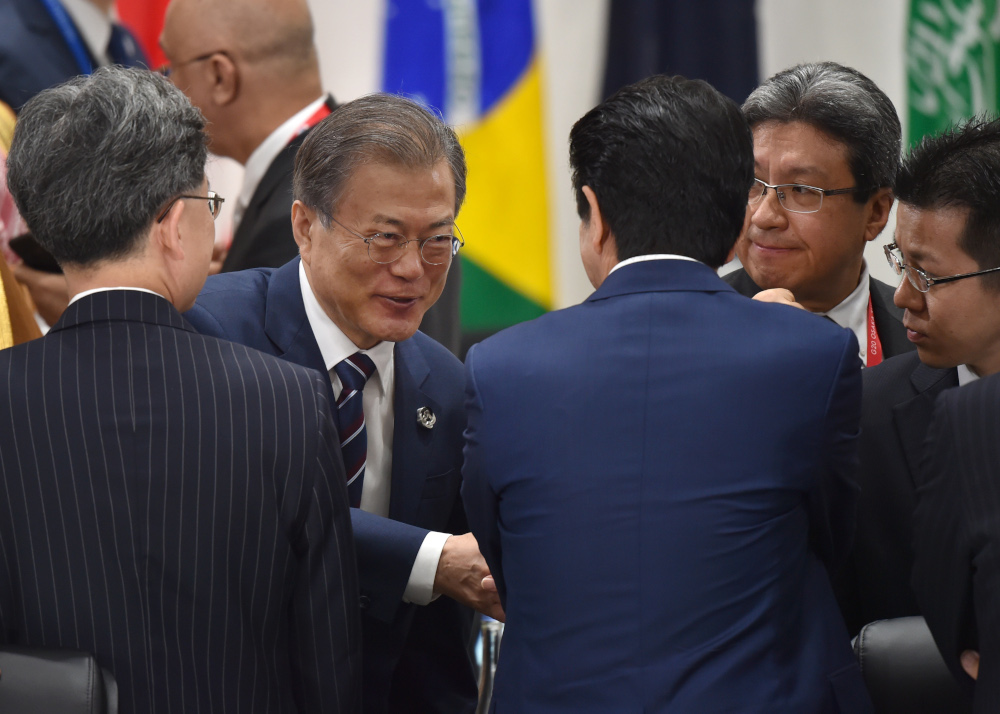South Koreau00e2u20acu2122s President Moon Jae-in and Japanu00e2u20acu2122s Prime Minister Shinzo Abe shake hands during the G20 Summit in Osaka June 29, 2019. u00e2u20acu201d AFP pic 