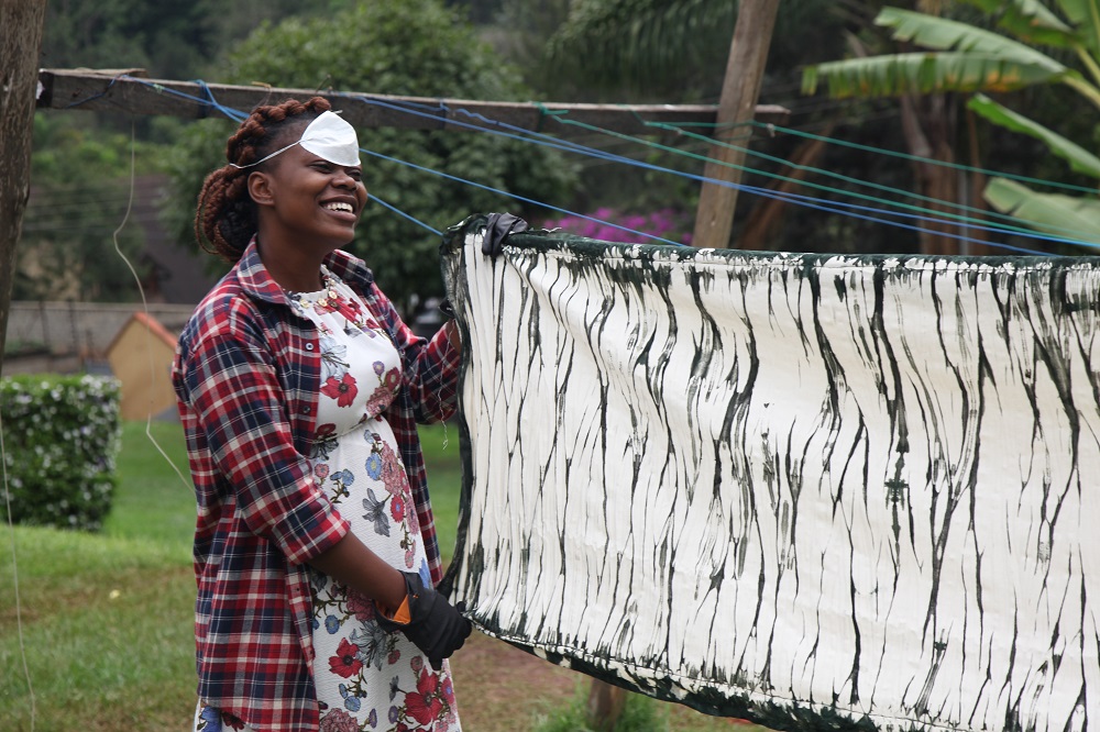 A refugee artisan hangs up hand dyed scarves for the MADE51 label at social enterprise RefuSHE in Nairobi June 13, 2019. — Thomson Reuters Foundation pic