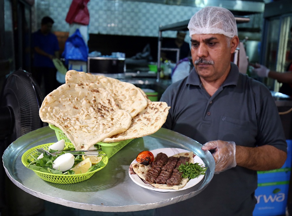 A waiter carries a tray with Iranian bread u00e2u20acu201d known as taftoon u00e2u20acu201d at the Al-Walimah restaurant in Kuwait City on June on June 27, 2019. u00e2u20acu201d AFP pic      