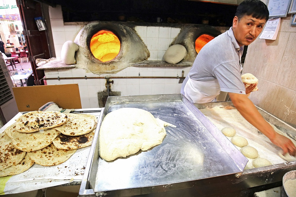A baker bakes Iranian bread — known as taftoon — at a bakery in Kuwait City on June on June 27, 2019. — AFP pic      