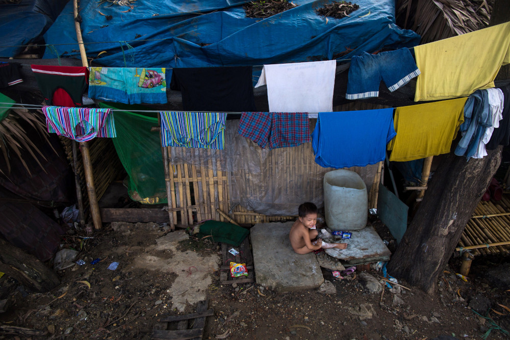 A child plays in front of his house in Hlaing Tharyar township on the outskirts of Yangon June 26, 2019. u00e2u20acu201d AFP pic 