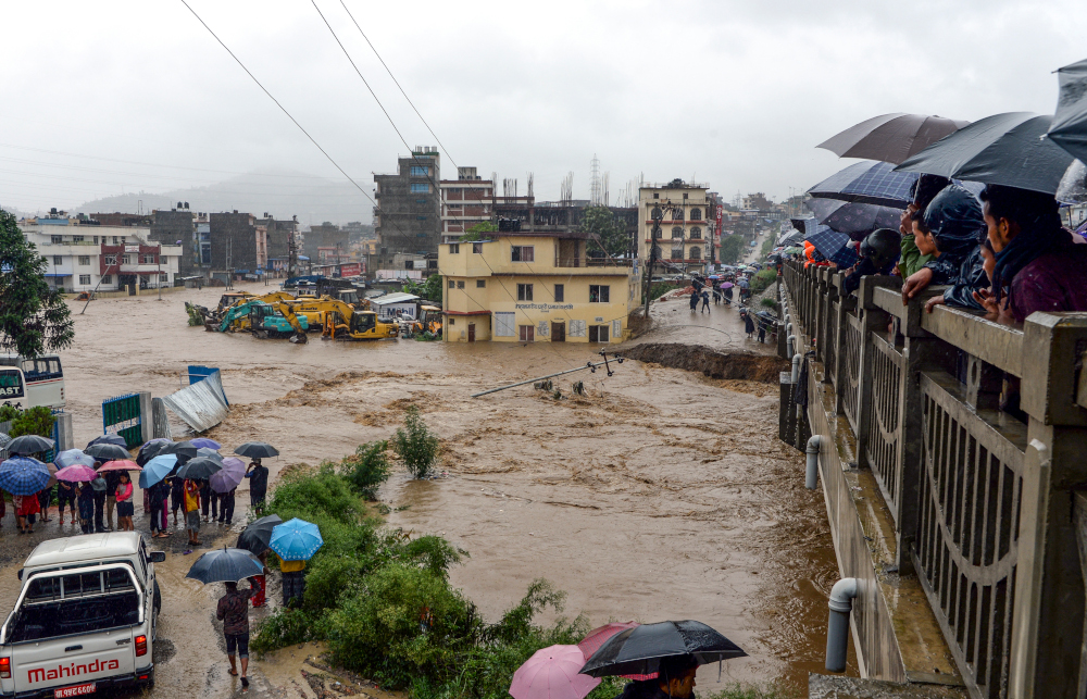 Nepali residents look at floodwaters after the Balkhu River overflowed following monsoon rains at the Kalanki area of Kathmandu July 12, 2019. u00e2u20acu201d AFP picn