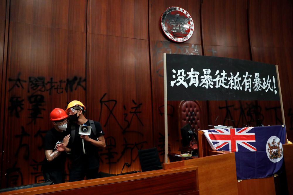 Protesters next to a Hong Kong colonial flag and banner displayed inside a chamber, after breaking into the Legislative Council building in Hong Kong July 1, 2019. The banner reads 'There are no thugs, only tyranny.' u00e2u20acu201d Reuters pic