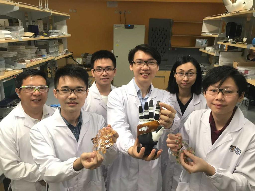 Assistant Professor Benjamin Tee (third from right) and some members of his National University of Singapore team, who have developed sensitive electronic skin that could be in commercial use in machines within two years. u00e2u20acu201d TODAY pic 