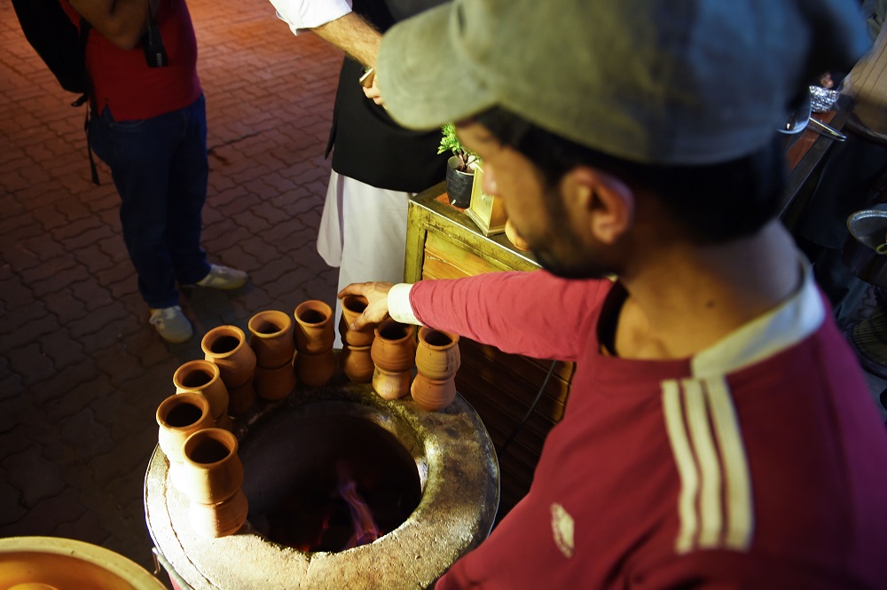 In this picture taken on March 29, 2019, a Pakistani worker places clay pots around a tandoor at a stall of a market in Islamabad. — AFP pic