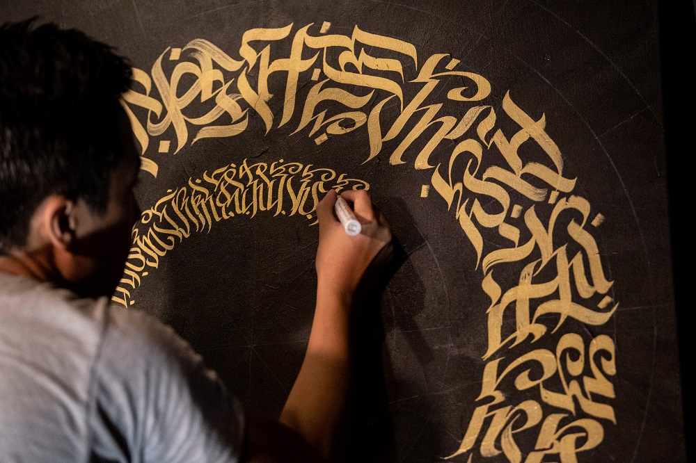 This photo taken on June 22, 2019 shows artist Taipan Lucero doing calligraphy using the indigenous script known as Baybayin, used before Spanish colonisation in 1521, at an event in Manila. u00e2u20acu201d AFP pic           