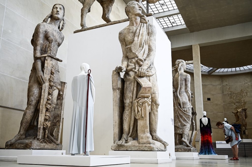 In this file photo taken on July 3, 2019 a woman looks at dresses displayed among large plaster casts by French sculptor Antoine Bourdelle at the Musee Bourdelle in Paris. — AFP pic