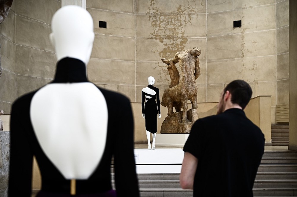 In this file photo taken on July 3, 2019 a man looks at a dress by Moroccan fashion designer Martine Sitbon (centre) displayed next to a large plaster cast by French sculptor Antoine Bourdelle at the Musee Bourdelle in Paris. — AFP pic