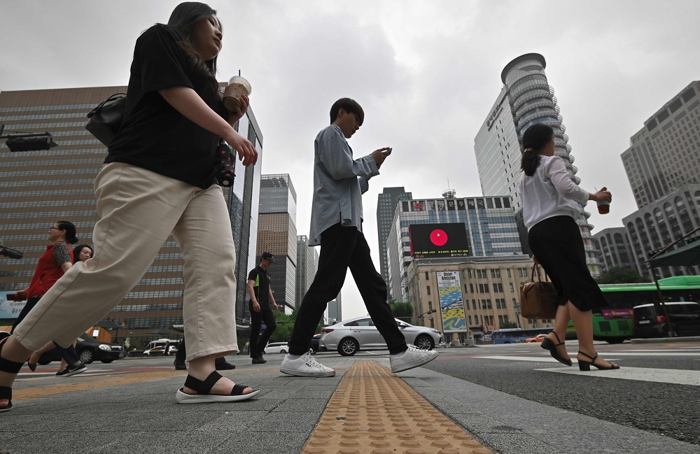 People walk cross a road at a business district in Seoul July 15, 2019. u00e2u20acu201d AFP pic        