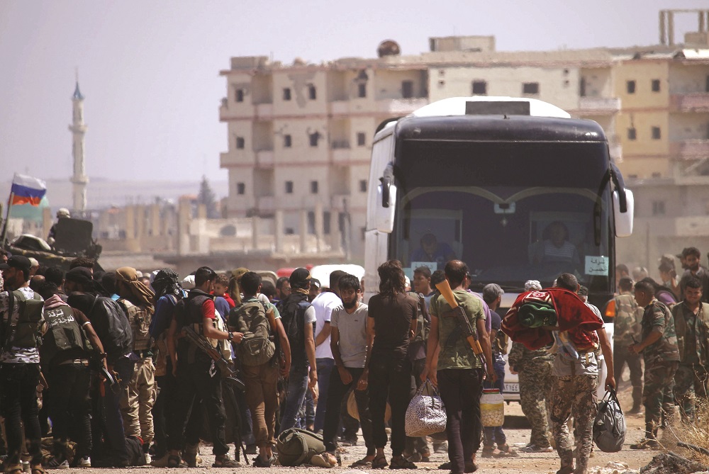 A file picture of Syrian rebels and their families standing by buses to be evacuated from Daraa city, on July 15, 2018. u00e2u20acu201d AFP pic  