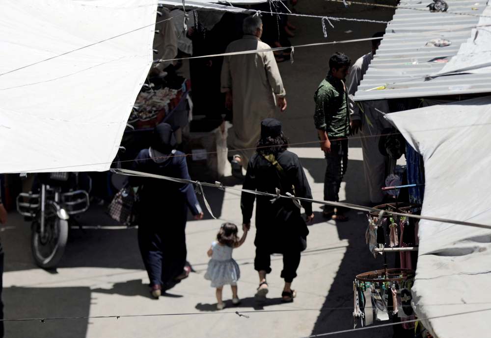 A man with a gun holds the hand of a child as they walk in a souk in the city of Idlib, Syria May 25, 2019. u00e2u20acu2022 Reuters file pic