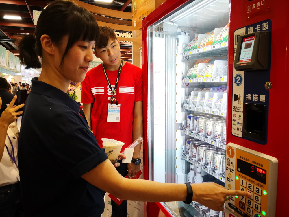 A visitor uses a halal vending machine at the Halal Taiwan expo. — Picture by Justin Ong