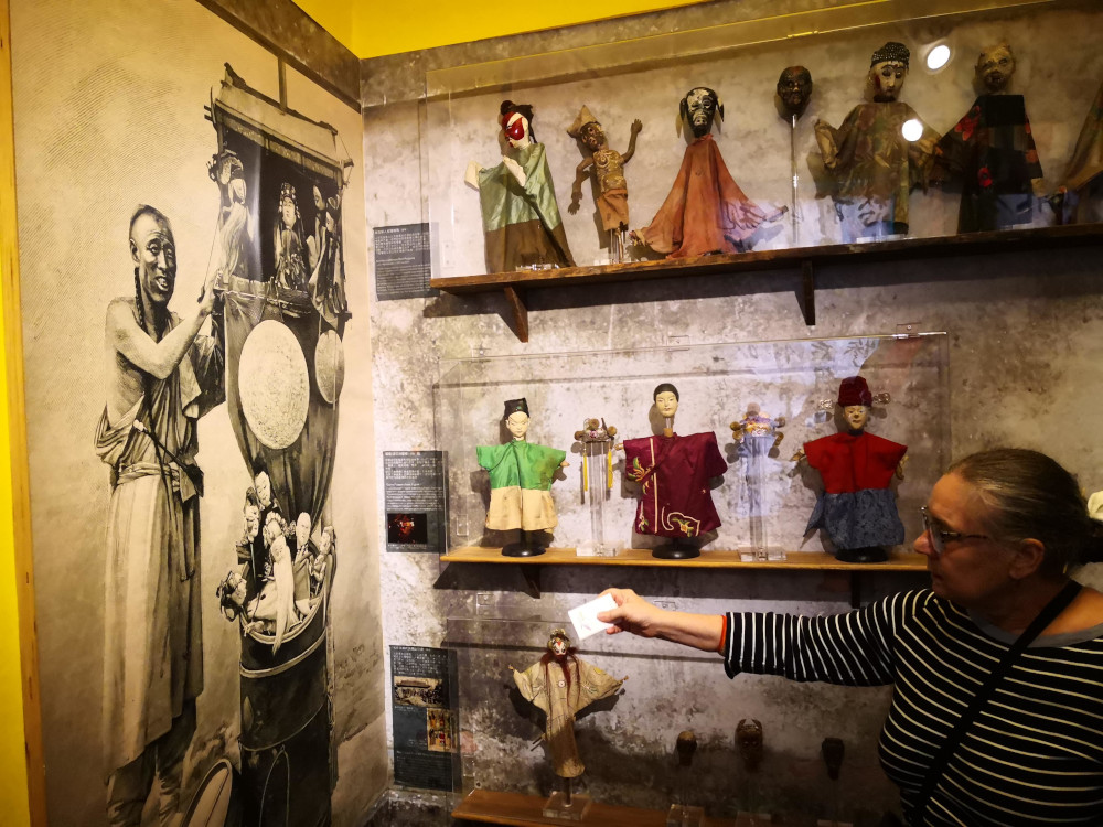 Conservator Kim Siebert explains the history of glove puppetry at the Taiyuan Asian Puppet Theatre Museum in Taipei, Taiwan. 